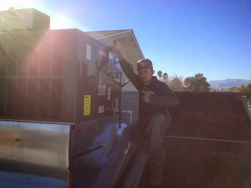 HVAC technician performing AC Tune-Up on a rooftop unit in Lake Elsinore